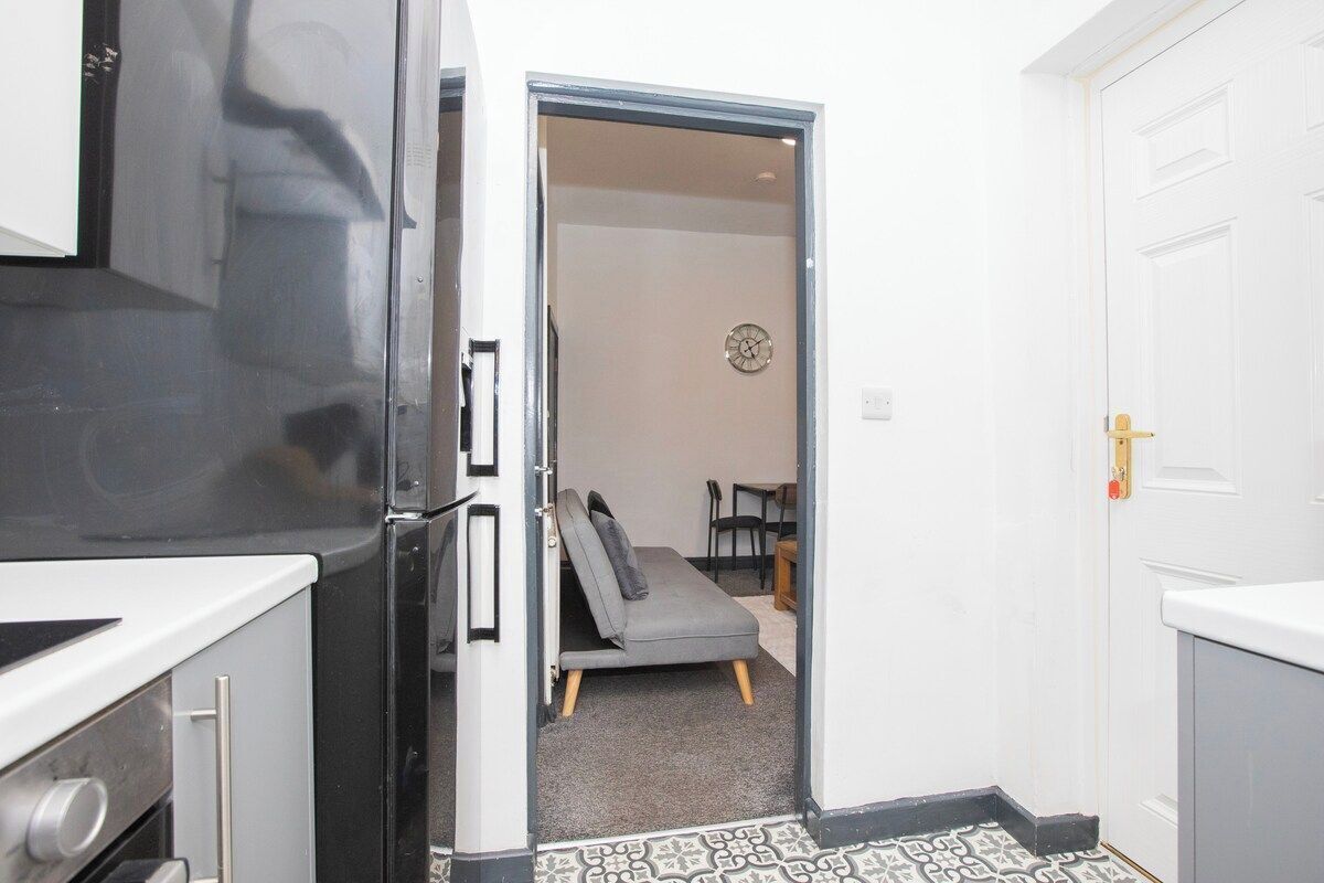 Eine kleine Küche mit Kühlschrank, Herd und Mikrowelle.