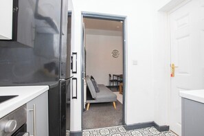 Une cuisine compacte équipée d’un réfrigérateur, d’une cuisinière et d’un four à micro-ondes.