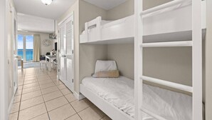Een hotelkamer met stapelbedden, een balkon met uitzicht en een kitchenette.