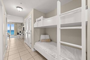 Ein Hotelzimmer mit Etagenbetten, einem Balkon und einer Küchenzeile.