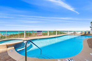 A pool area with a clear view of the ocean, a pool area sign, and a lifeguard stand. - Seychelles Beachfront Condo | Gulf Views + Pools (Panama City Beach)