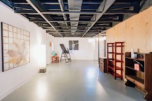 Eine Kunstgalerie mit poliertem Betonboden, Holzlagerregalen und abstrakten Gemälden.