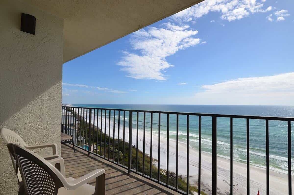 A balcony with a view of the ocean and beach.