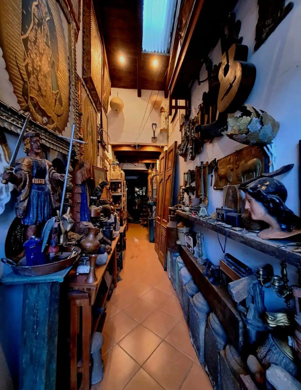 A narrow corridor with shelves on both sides displaying various items.