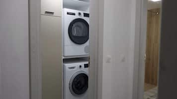 A laundry room with two stacked washing machines and a dryer.