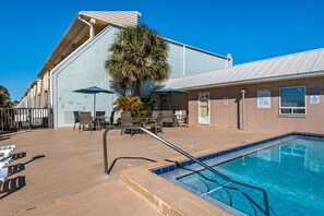 A pool area with lounge chairs, a palm tree, and signs indicating pool rules. - 2BR Beachfront Townhome on PCB West End + Free Tix: Dolphin Cruise & More! (Panama City Beach)