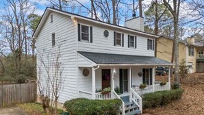 A two-story house with a front porch, a garage, and a fenced yard.