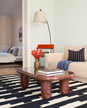 Ein modernes Wohnzimmer mit einer Couch, einem Couchtisch und einer Lampe.