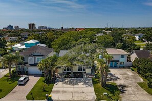 A residential area with houses, a driveway, and a parked car. - Pier Escape - Entire Property (Jacksonville Beach)