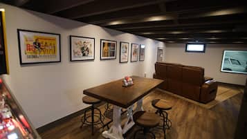 A room with a wooden table, stools, a cushioned bench, and framed movie posters on the wall.