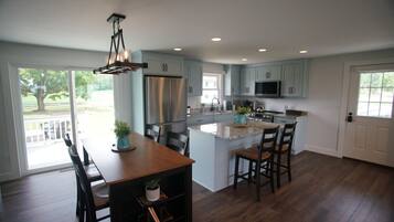 A spacious kitchen with a central island, stainless steel appliances, and light blue cabinetry.