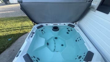 A hot tub with a hexagonal interior, positioned on a wooden deck.