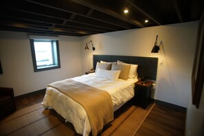 A bedroom with a bed, bedside lamps, a window, and a ceiling light. - Black, White, & Barn w/ Hot Tub & Fire Pit (Fredericktown)
