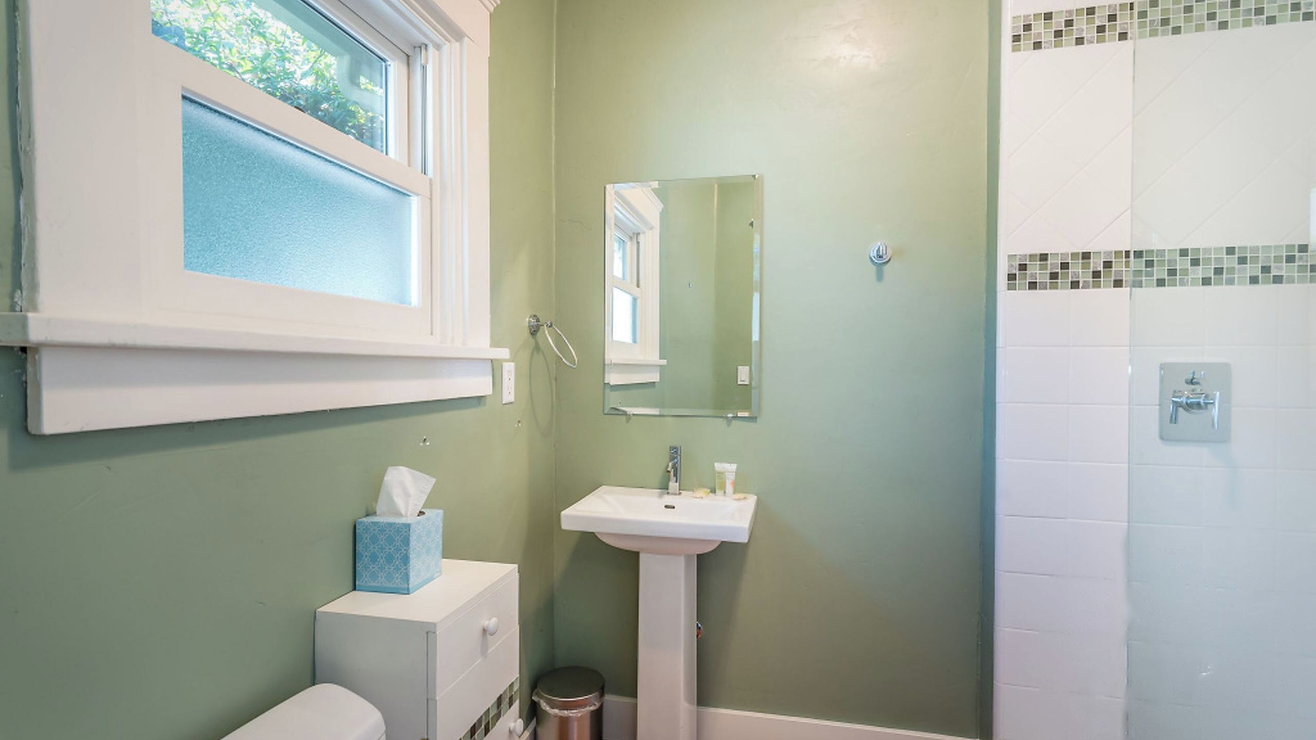 Une salle de bain avec des toilettes, un lavabo et une douche.