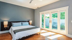 A bedroom with a bed, nightstands, and a sliding glass door leading to a backyard. - Bungalow on Vine by Avantstay Walkable Downtown + Private Yard Paso Robles Wine Country (Paso Robles)