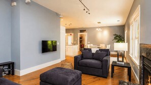 A modern living room with a sofa, ottoman, and a flat-screen TV. - Bungalow on Vine by Avantstay Walkable Downtown + Private Yard Paso Robles Wine Country (Paso Robles)