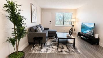A modern living room with a sofa, coffee table, and a television.