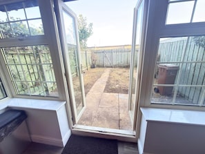 Une pièce dotée d’une grande porte-fenêtre coulissante donnant sur un patio extérieur.