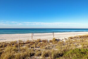 A beach with a volleyball net, sandy beach, and grassy dunes. - 3BR Edgewater Condo Pools, Golf, Tennis & Private Beach Access! (Panama City Beach)