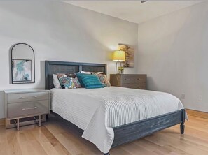 A bedroom with a bed, bedside tables, a lamp, and a painting on the wall. - Spacious 3-bedroom condo with amazing Beach front views of the Gulf! (Sarasota)