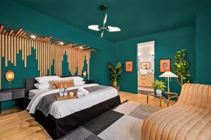 Ein modernes Schlafzimmer mit Bett, Nachttischen, Deckenventilator und Spiegel.