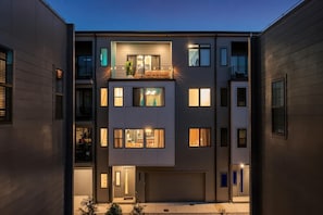 Ein mehrstöckiges Wohngebäude mit Garage, Balkonen und zahlreichen Fenstern.