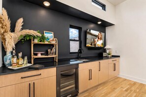A modern kitchen with a black countertop, wooden cabinets, a built-in oven, and a window with a view. - Nashville group house: neon balcony, 4 king suites, sleeps 12 near The Gulch (Nashville)