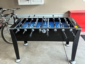 A foosball table with a bicycle in the background. - The Historic Sugar Mill House with Hot Tub (Loveland)