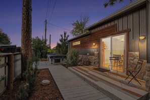 A wooden cabin with a patio, outdoor seating, and a stone wall. - The Historic Sugar Mill House with Hot Tub (Loveland)