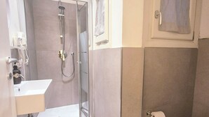 A bathroom with a glass-enclosed shower, a white sink, and a toilet. - Lady Flor B&B (Firenze)