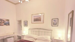 A bedroom with a bed, bedside tables, a dresser, a mirror, and a chandelier. - Lady Flor B&B (Firenze)
