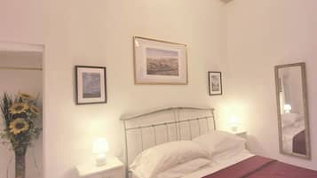 Ein Schlafzimmer mit einem Bett, einem Nachttisch, einem Spiegel und einem Fenster mit Blick.