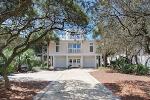 A two-story house with a front entrance, a driveway, and a well-maintained garden. - 5BR Gulf-front Home With Private Beach & Heated Pool - Sleeps 12 (Panama City Beach)