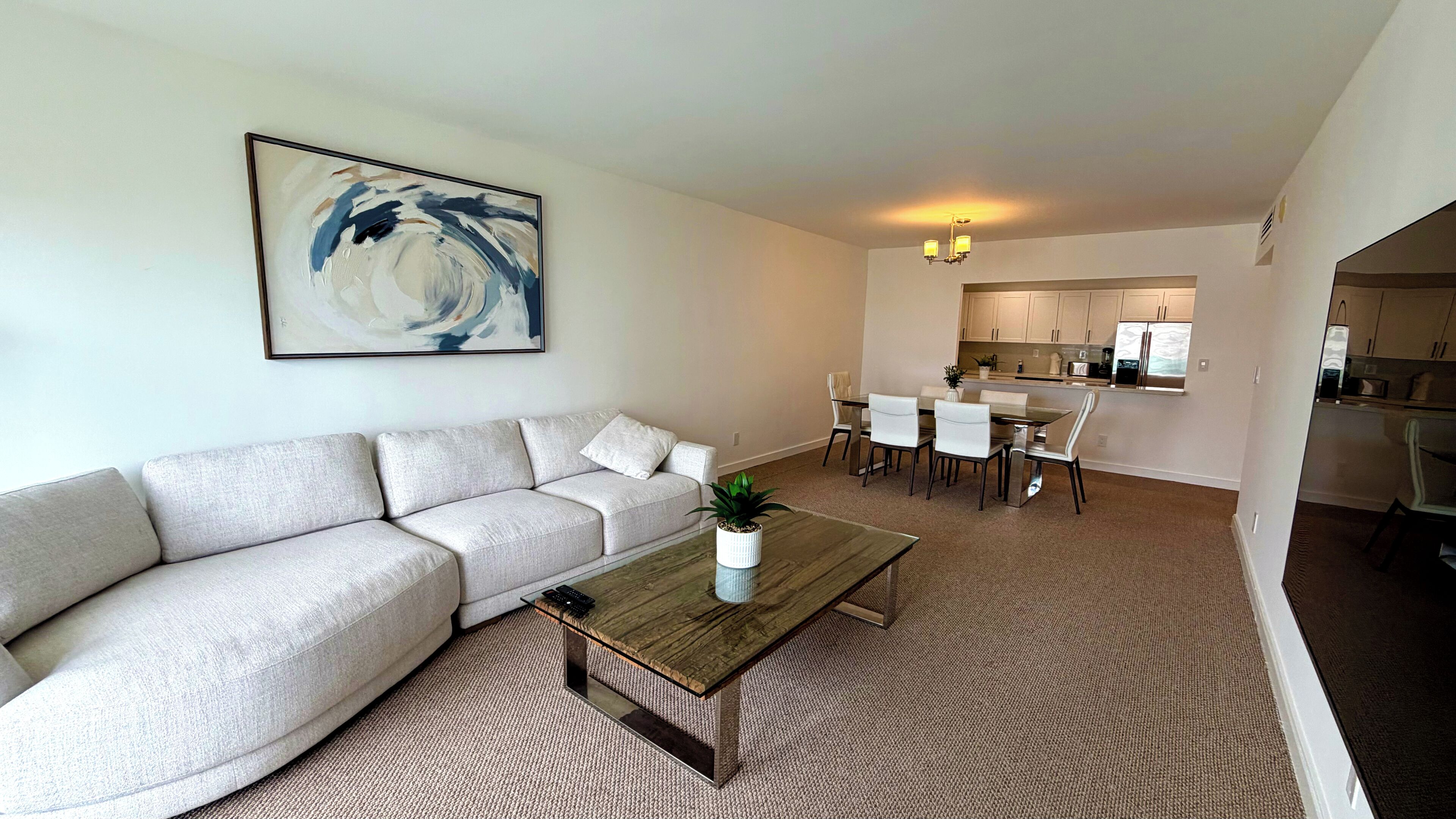 A modern living room with a sofa, coffee table, and a painting.