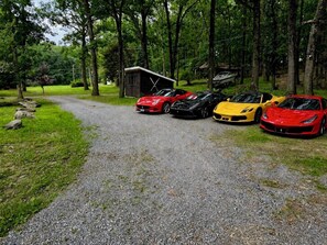 A gravel path leading to a row of parked sports cars.