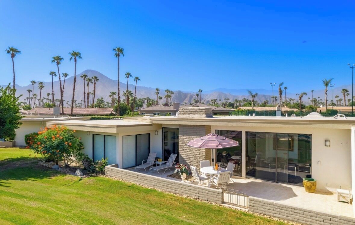 Ein modernes Haus mit Terrasse, Pool und Bergblick.