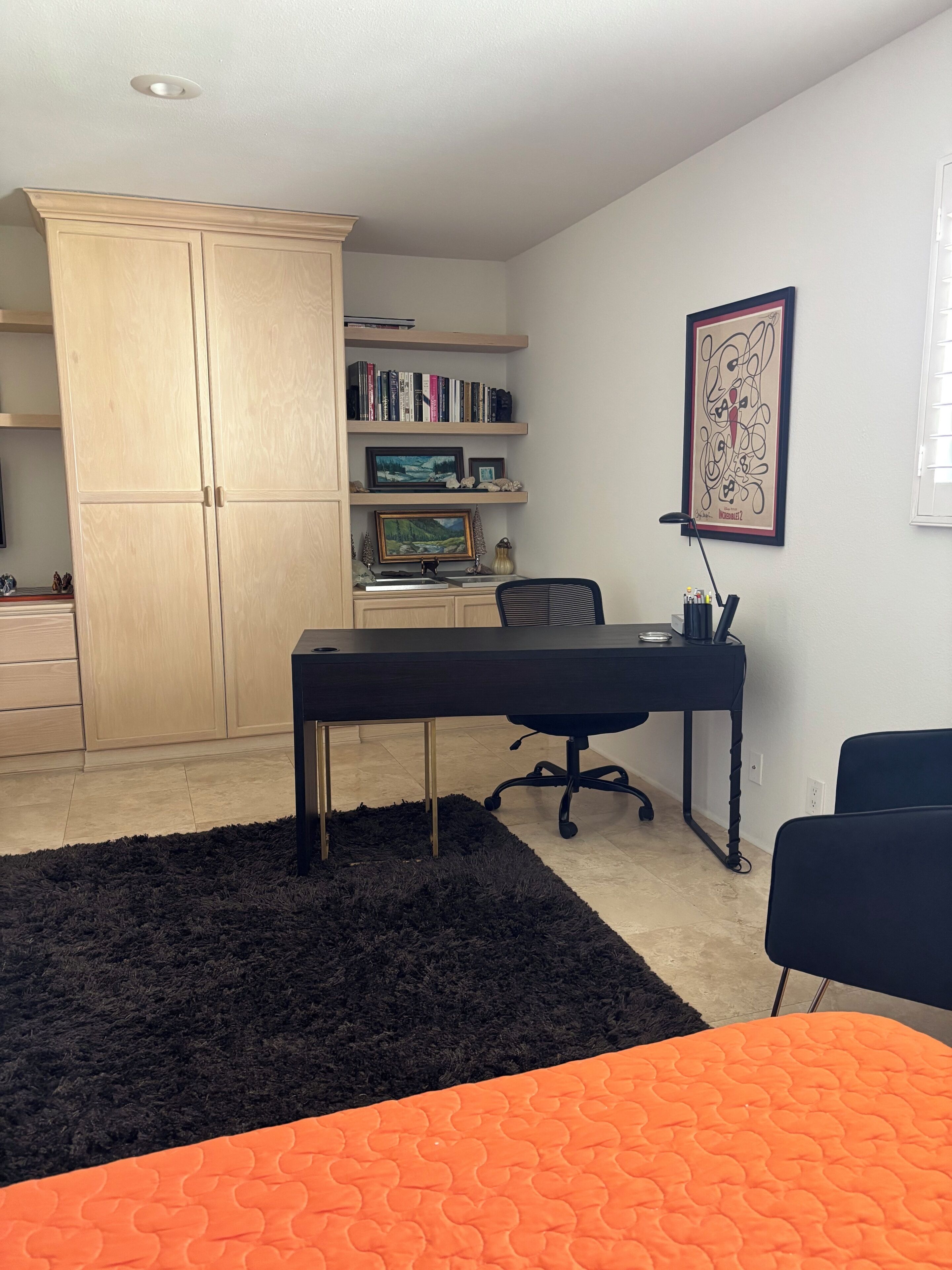 Une pièce comprenant un bureau, une chaise, une bibliothèque et une grande armoire.