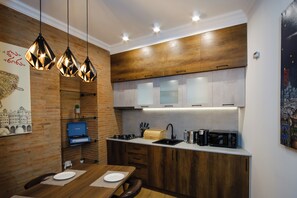 A modern kitchen with wooden cabinets, a built-in microwave, and pendant lighting.