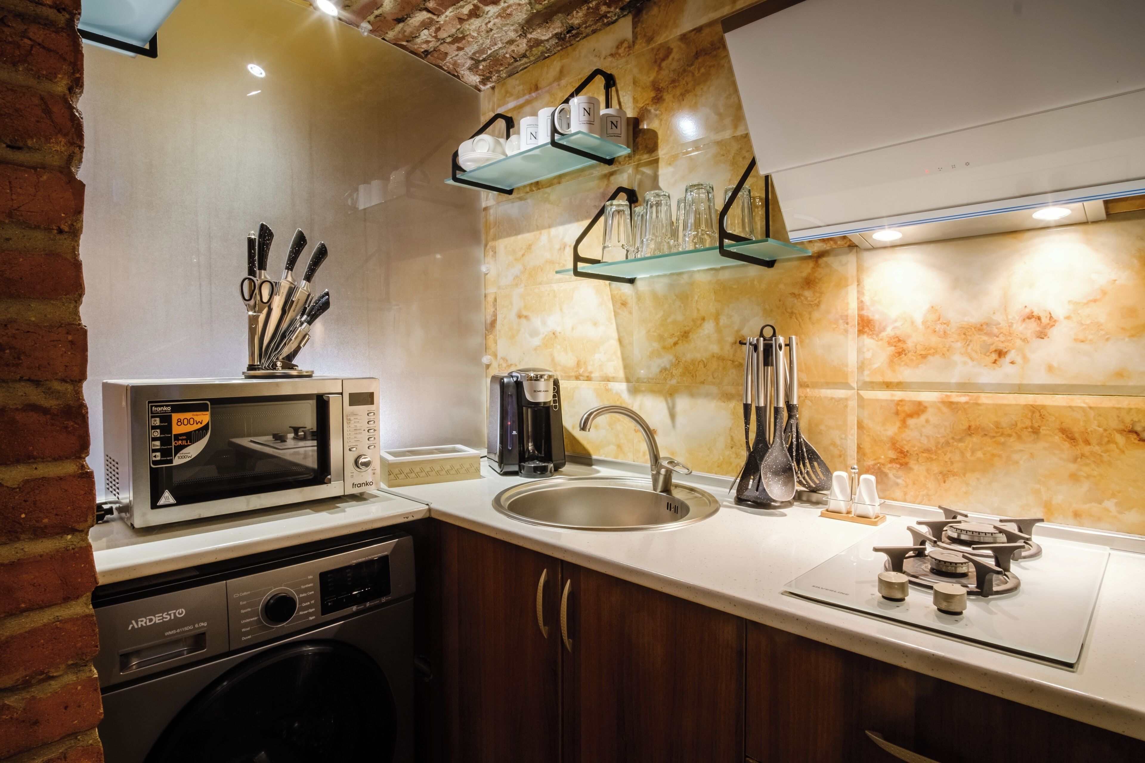 A kitchen with a microwave, sink, and a coffee maker.