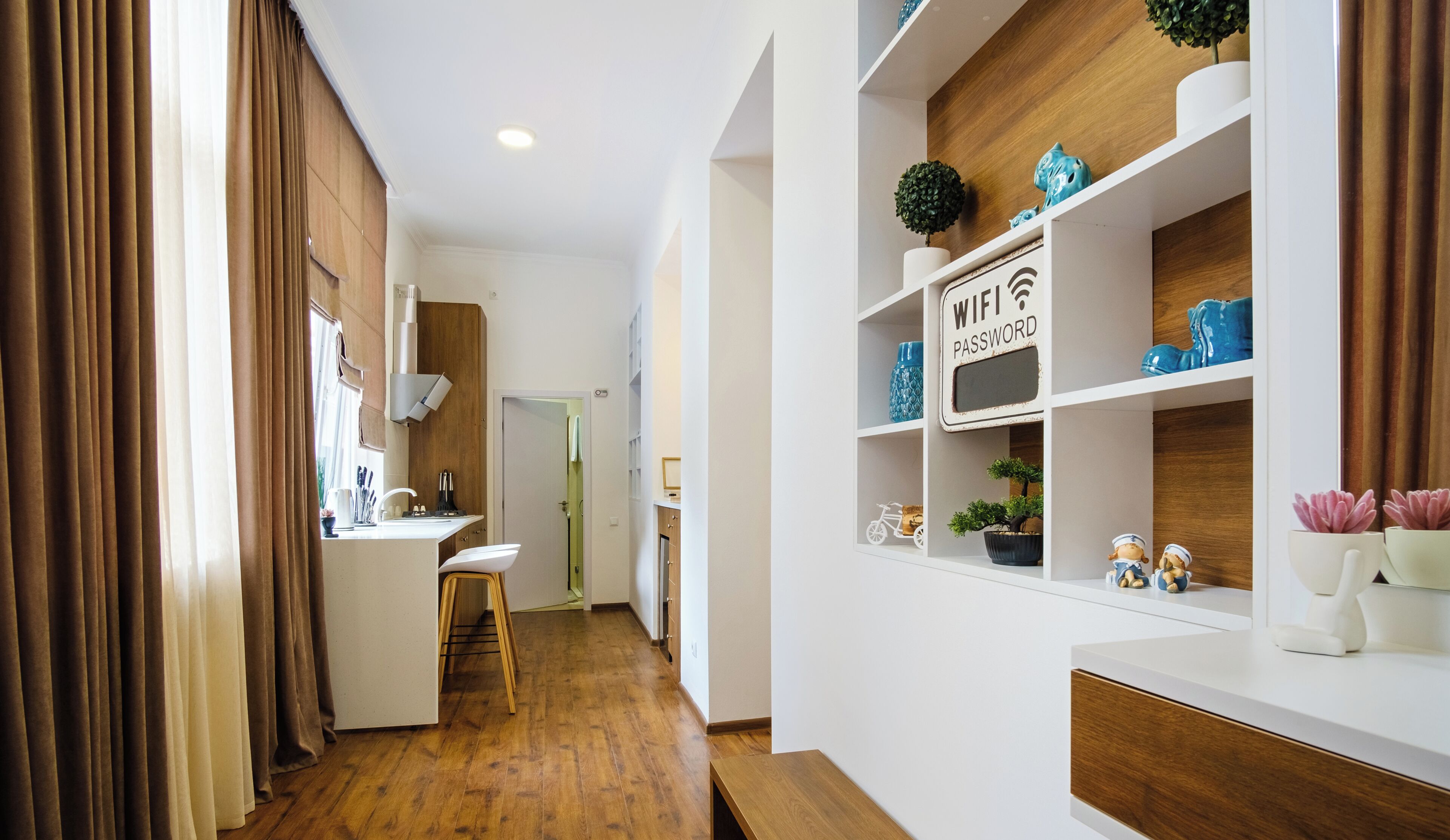 Cocina moderna con encimera de madera, un lavamanos y una zona de comedor con una silla.