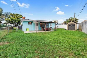 Ein Wohnhaus mit eingezäuntem Garten, einer kleinen Veranda und einer Garage.