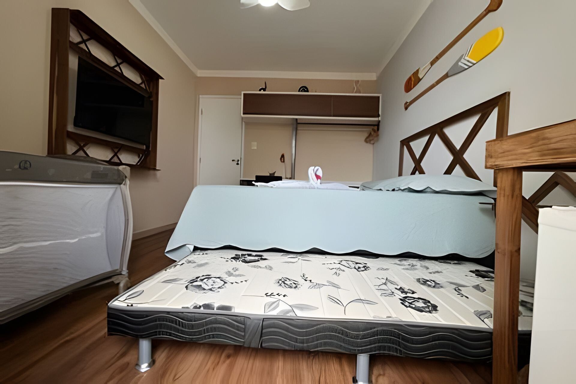 A compact bedroom with a bed, a window, and a wooden headboard.