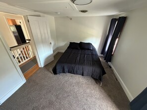 A bedroom with a bed, a door, a staircase, and a window with curtains. - Village View B&B,Convenient 2-bedroom apartment in lovely Lahaska, Bucks County (Lahaska)