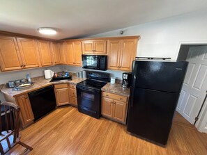 A kitchen with wooden cabinets, a black refrigerator, a microwave, an oven, and a coffee maker. - Village View B&B,Convenient 2-bedroom apartment in lovely Lahaska, Bucks County (Lahaska)