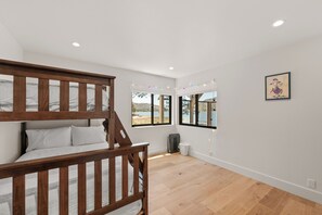 A room with a bunk bed, large windows, and a view of a lake. - Emerald Lakefront Chalet (Big Bear Lake)