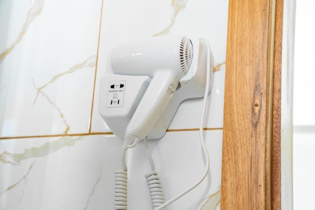 A hair dryer mounted on a wall with a wooden frame.