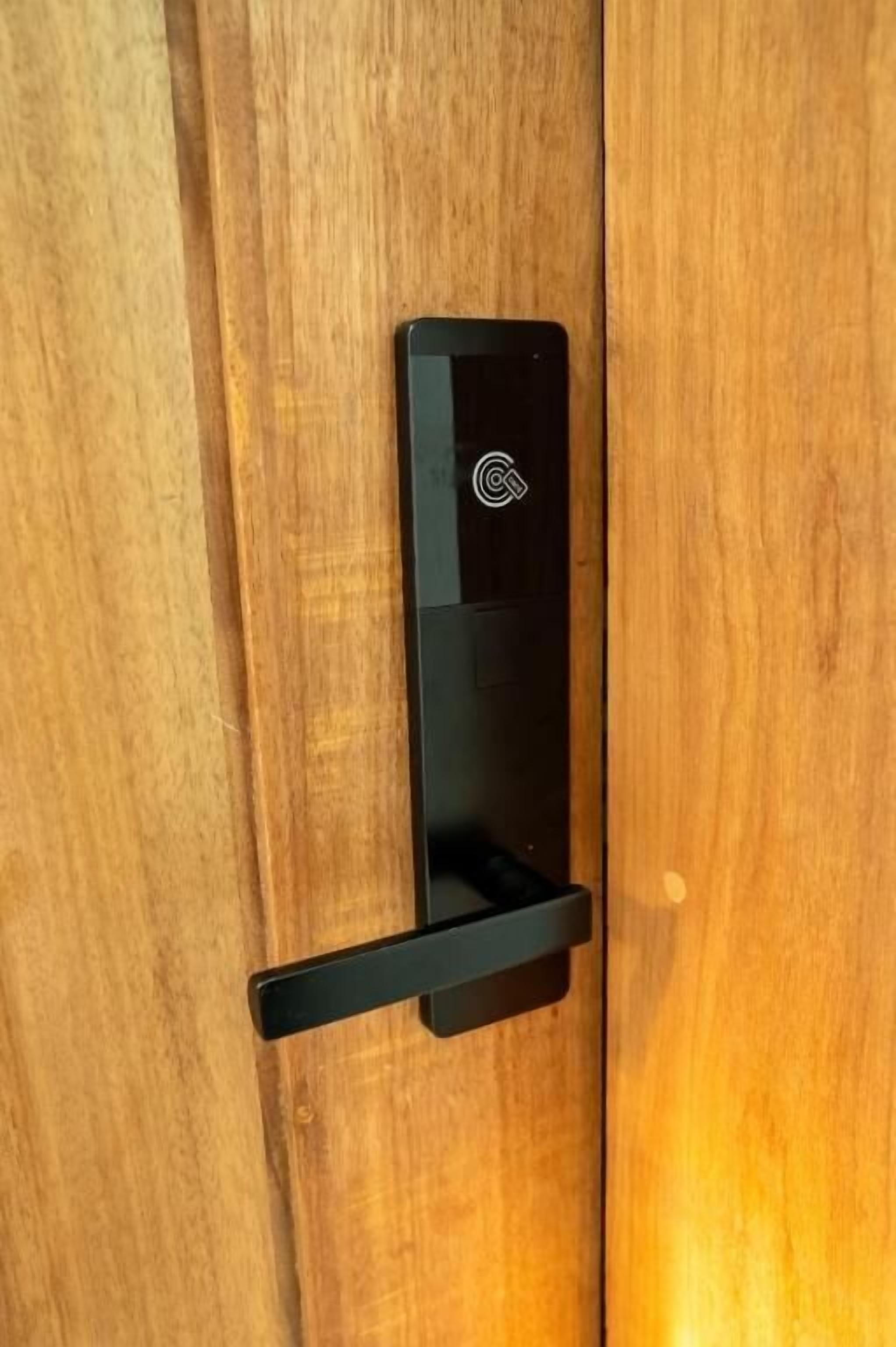 A black door handle on a wooden door.