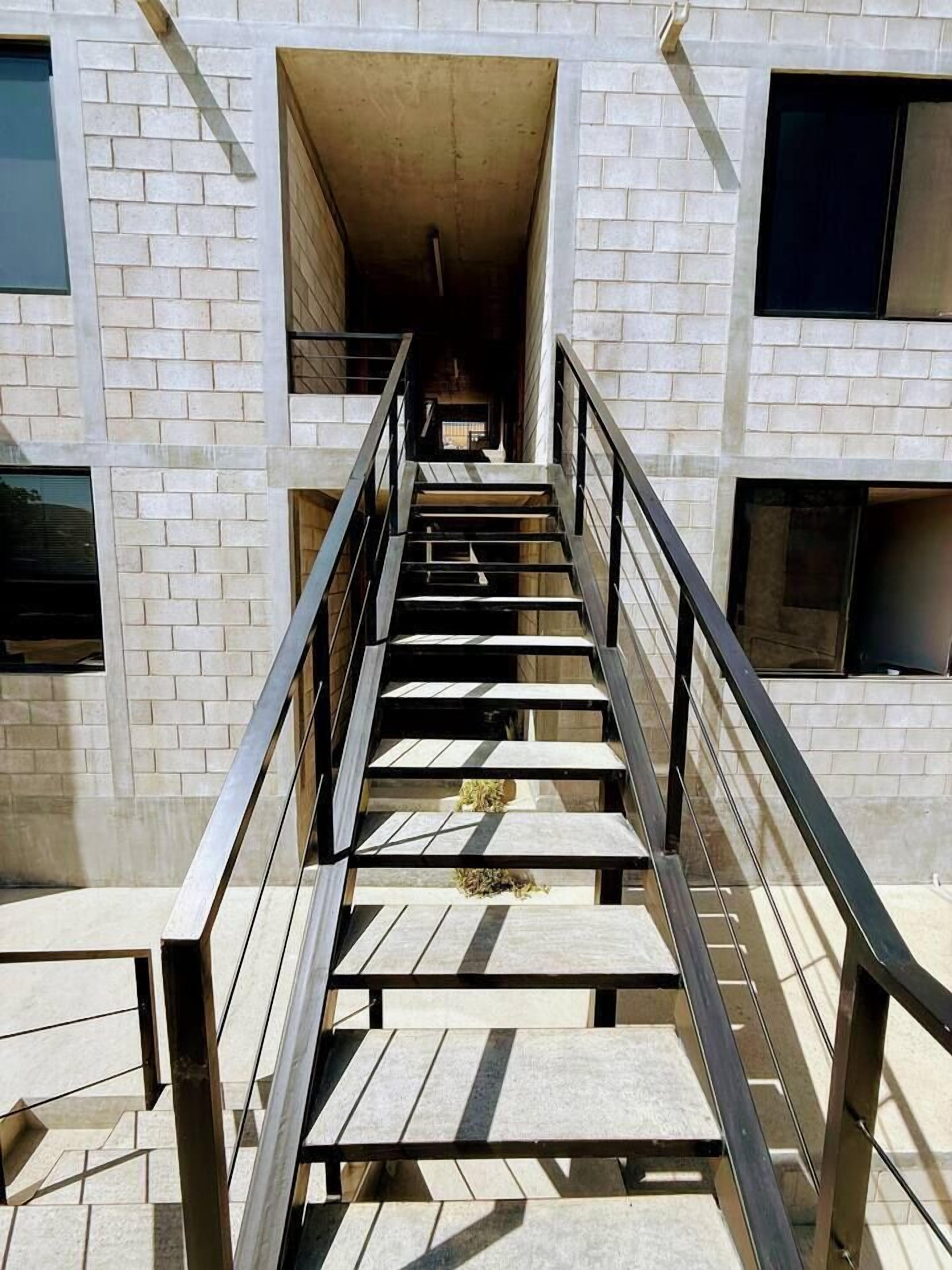 Una escalera que lleva a la entrada de un edificio con fachada de ladrillo.