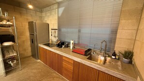 A modern kitchen with a built-in oven, stainless steel appliances, and a wooden countertop.