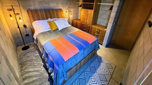 Ein Schlafzimmer mit einem Bett, Nachttischlampen, einem Kleiderschrank und einem Deckenventilator.